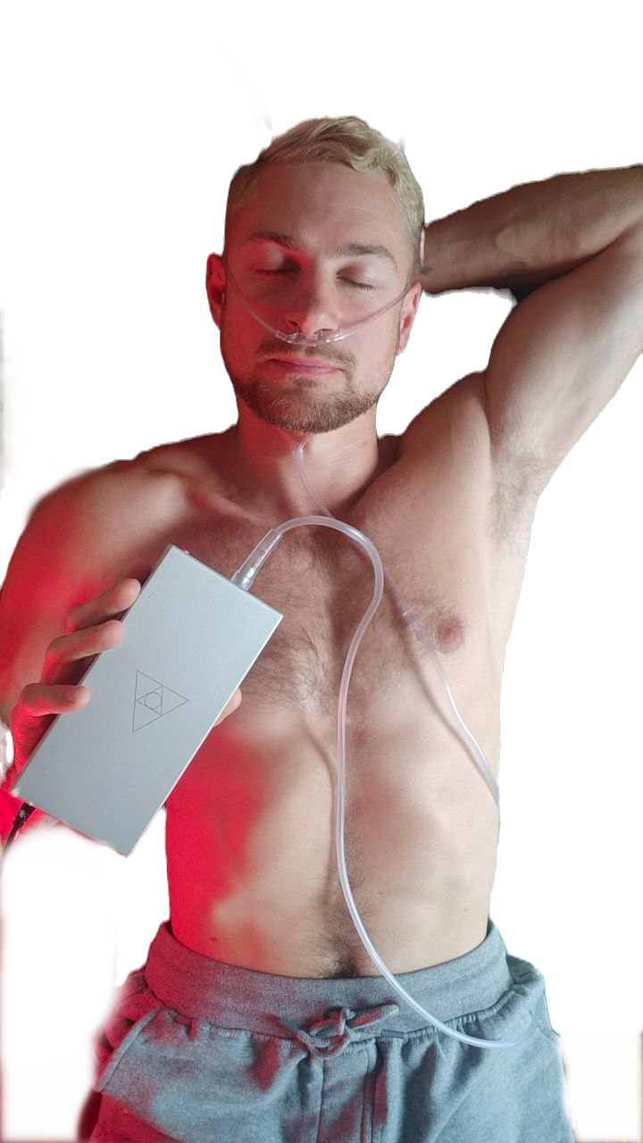 Man with a nasal cannula, eyes closed, holding the Forest Air Home to his chest.
