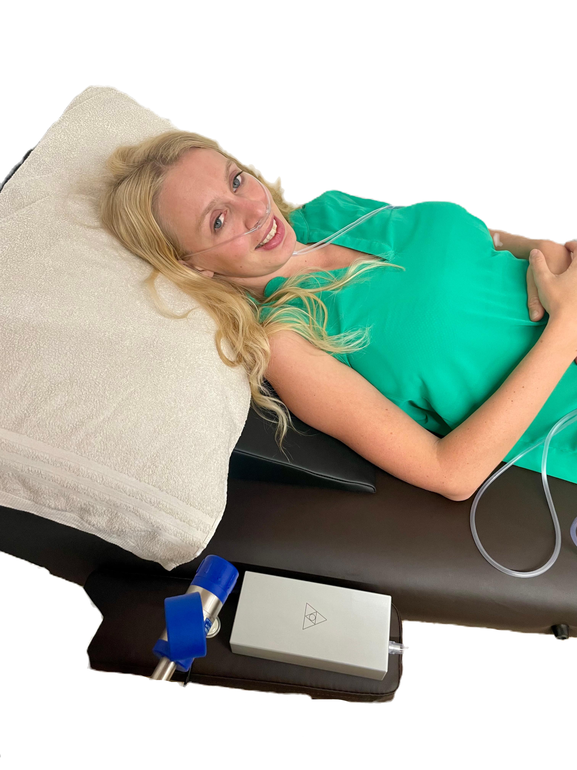Woman lying on a couch, the nasal cannula running to the Forest Air Home beside her.